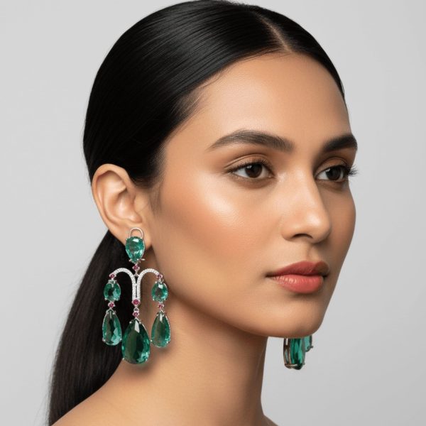 "Woman wearing emerald green multi-drop chandelier earrings with teardrop stones and luxury design"