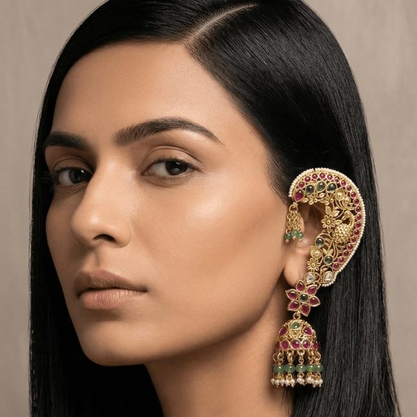 "Woman wearing kundan ear cuff jhumka earrings with red and green stones and traditional Indian design"