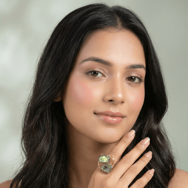 A lifestyle close-up of a woman wearing a modern gold ring by Belsi's Jewelry featuring two interlocking labradorite gemstones