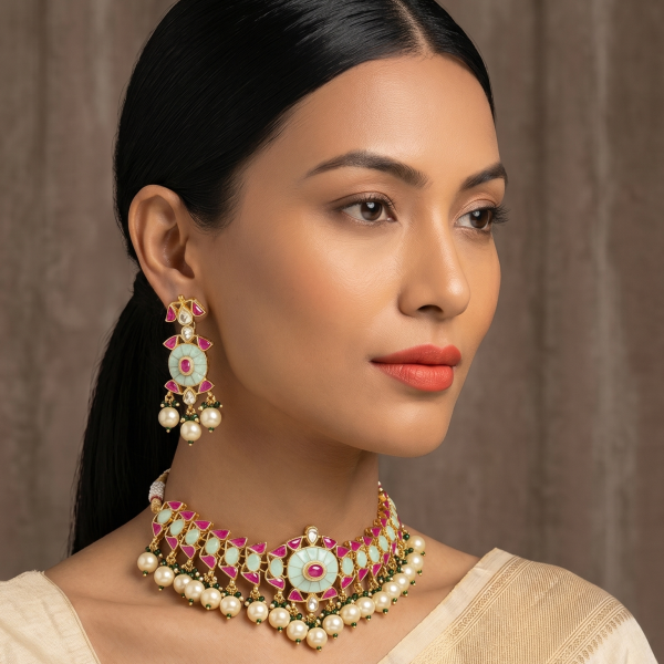 Close-up of an Indian model wearing a mint green choker necklace with ruby-red accents and pearl droplets, paired with matching drop earrings.