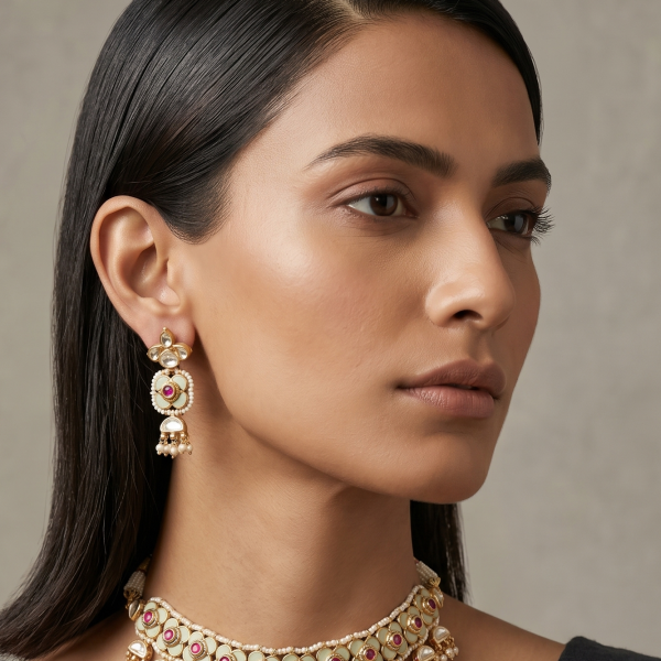 Side-profile of a model wearing a mint green Kundan choker with ruby-red stones and matching earrings.
