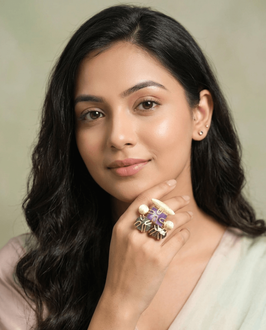 Amethyst and Labradorite Artisanal Statement Ring – Handcrafted Gold Wire-Wrapped Cocktail Ring 1 a woman wearing an intricate gold ring with a purple amethyst center and dark, iridescent caged labradorite gemstones on her hand.