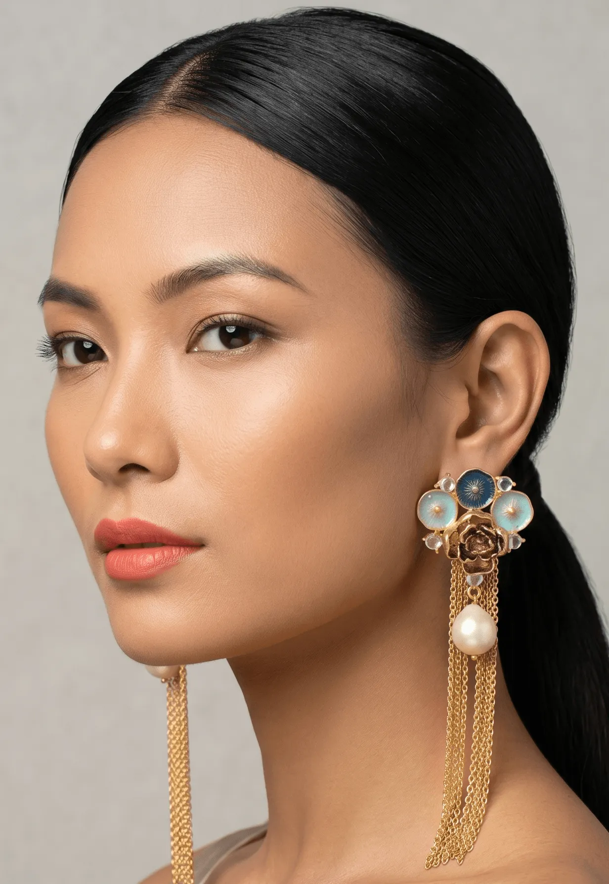 Flower Power Gold Geometric Fan Tassel Earrings with Indigo & Turquoise Blue Enamel 1 Close-up portrait of a model showcasing Belsi's Jewelry Flower Power collection long statement earrings, featuring a golden rose stud topped with a fan of hand-painted deep indigo and light turquoise blue enamel circles, clear stone borders, a central hanging round pearl, and long gold chain fringe tassels.