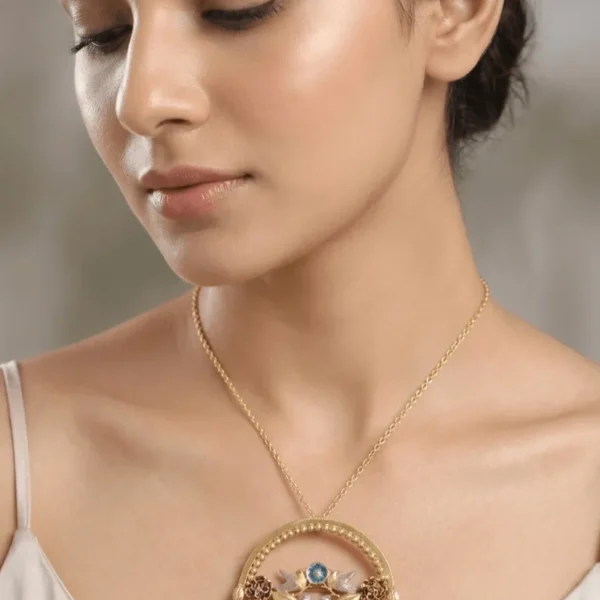 A high-fashion editorial close-up of a model wearing a large circular gold statement pendant with handcrafted leaves, peacock blue floral rosettes, and a dark central gemstone.