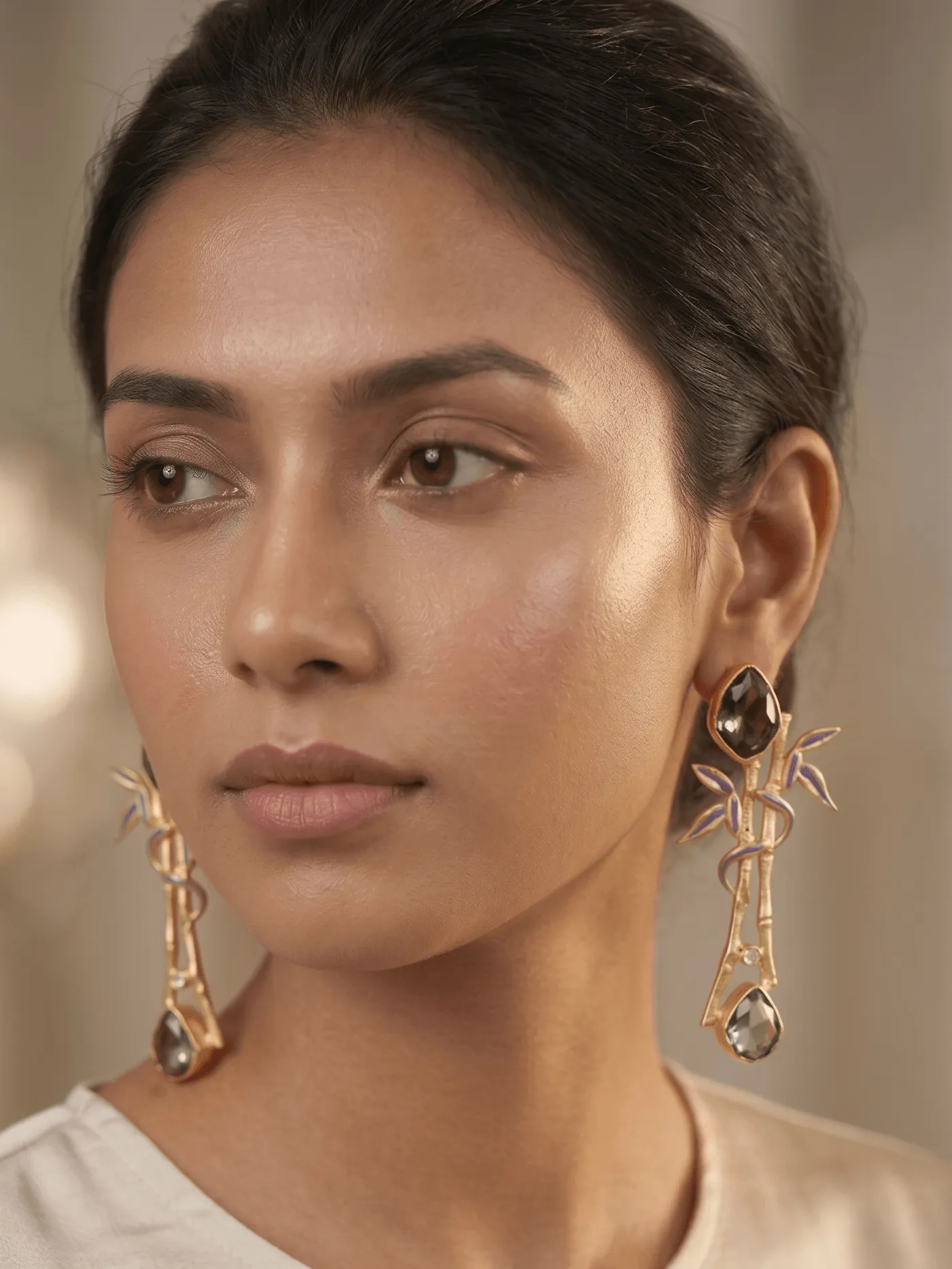 Zen Enamelled Bamboo Branch Drop Earrings with Slate Grey Gemstones 1 A pair of gold-tone statement earrings shaped like textured bamboo branches, featuring slate grey enamel leaf inlays, subtle crystal accents, and faceted smoky slate grey gemstones.