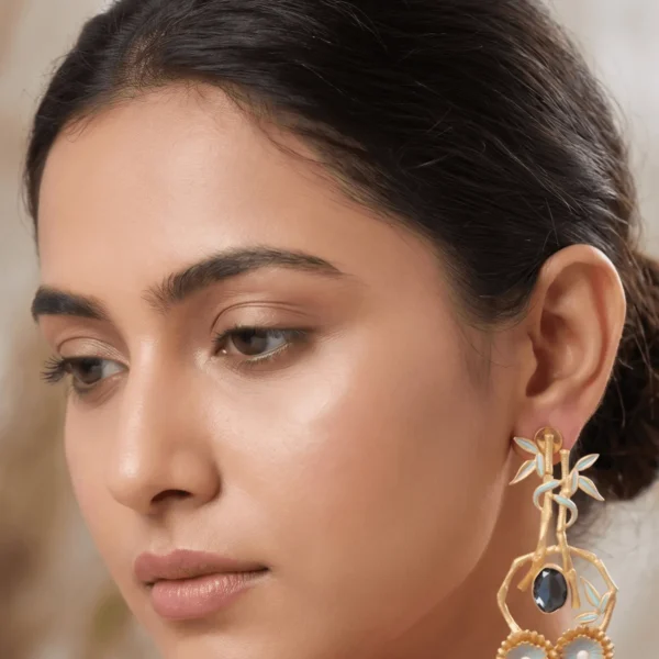 Close-up of a model wearing large, ornate gold-tone chandelier statement earrings featuring powder blue enamel accents on a structural bamboo framework, a central dark smoky faceted gemstone, and dual fluted floral wheels hanging at the base.