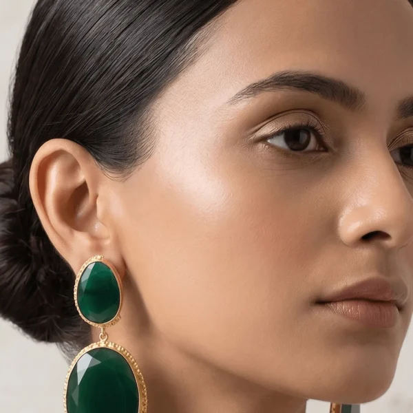 Belsi's Jewelry two-tier statement drop earrings featuring an oval emerald green quartz top stone and a large, faceted deep green teardrop crystal encased in handcrafted gold-plated borders.