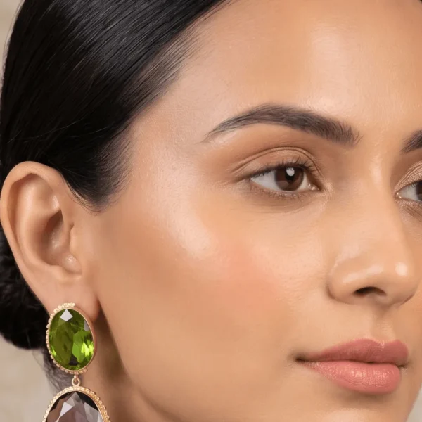 Belsi's Jewelry two-tier statement drop earrings featuring a faceted olivine lime green quartz stone paired with a large, teardrop smoky purple-brown amethyst quartz stone in handcrafted gold frames.