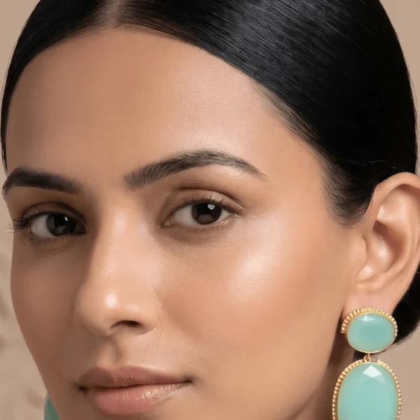 Belsi's Jewelry two-tier statement drop earrings featuring an oval mint green quartz top stone and a larger, matching faceted mint green teardrop crystal encased in handcrafted gold-plated borders.